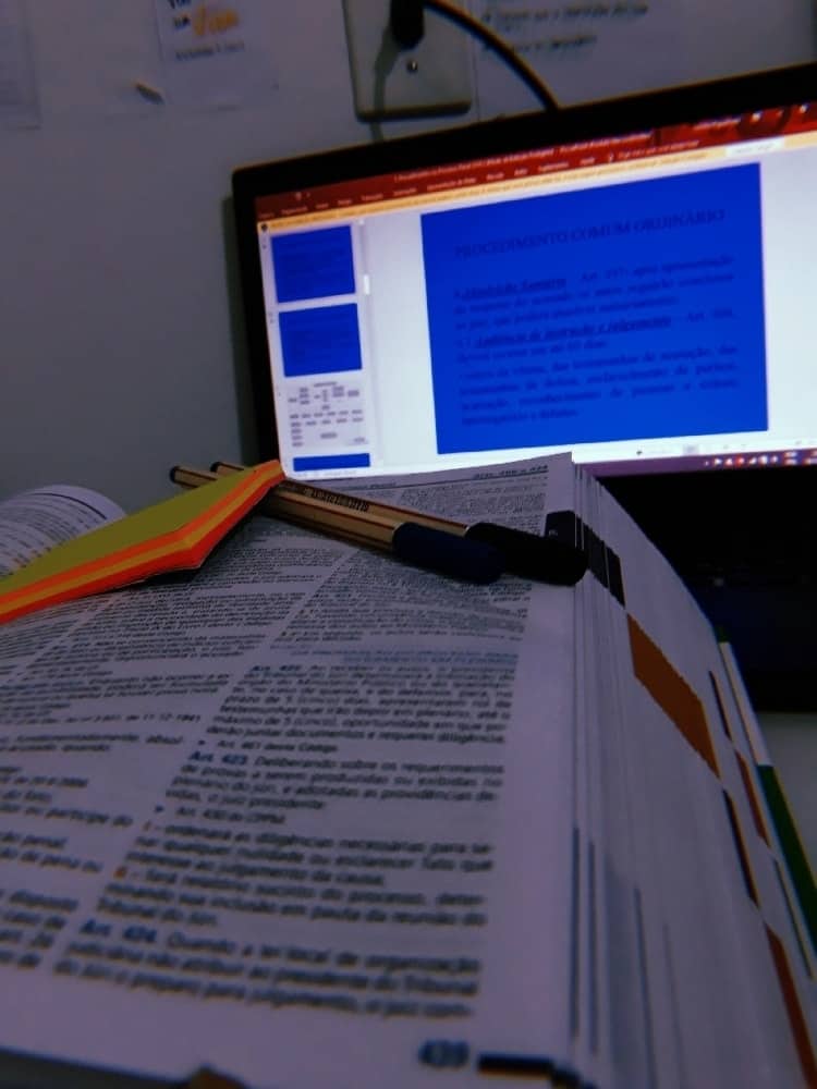 Close up of law school textbook with post it, pen and laptop computer screen in background to show final test anxiety attack